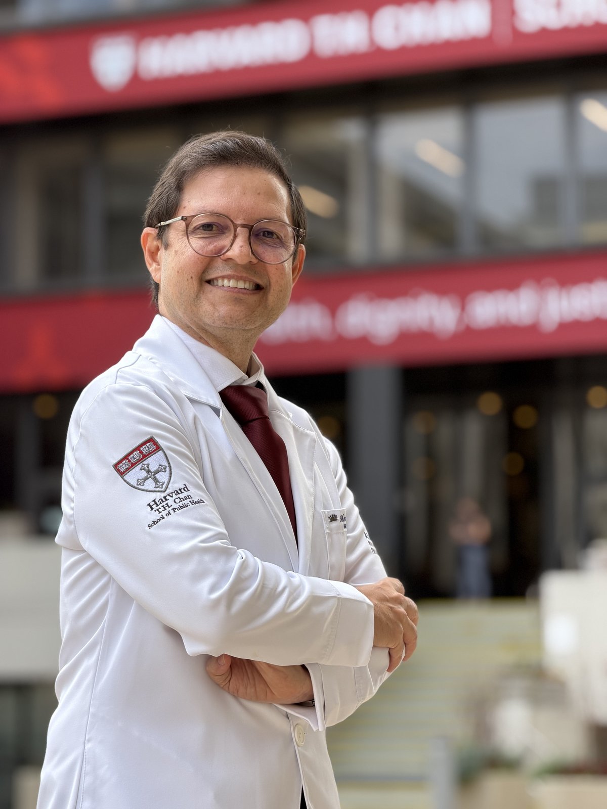 Moisés Barbosa com jaleco da Harvard T.H. Chan School of Public Health